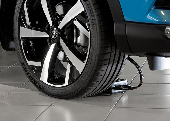 ShowroomCharger behind car wheel in a showroom environment